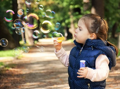enfance et sagesse moment présent jeune enfant qui fait des bulles de savons