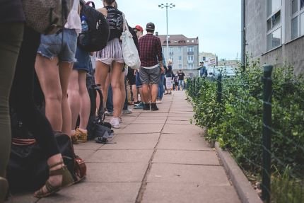 L'art d'attendre sans stress : Transformer l'impatience en alliée 4 Attendre vue de jambes d'une longue file d'attente