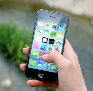 L'art d'attendre sans stress : Transformer l'impatience en alliée 3 Attendre main qui scrolle sur un écran de smartphone