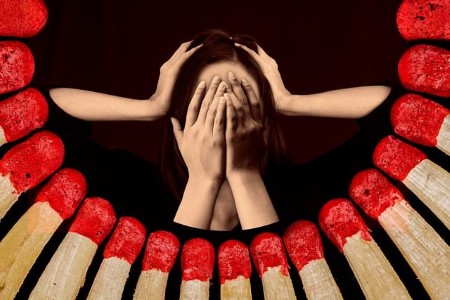 Congé Menstruel et Oubli de la Ménopause : pour une Santé Inclusive au Travail à Tout Âge 5 Congé menstruel ménopause tête de femme avec des mains sur le visage et sur la tête. Entourée d'allumette pour symboliser le stress et le burn out