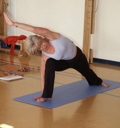 Congé Menstruel et Oubli de la Ménopause : pour une Santé Inclusive au Travail à Tout Âge 7 Congé menstruel ménopause Femme faisant du yoga pendant sa pause méridienne